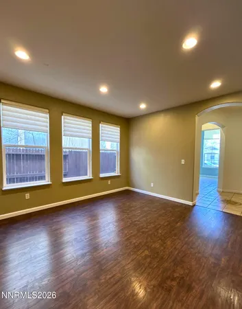 an empty room with wooden floor and chandelier fan