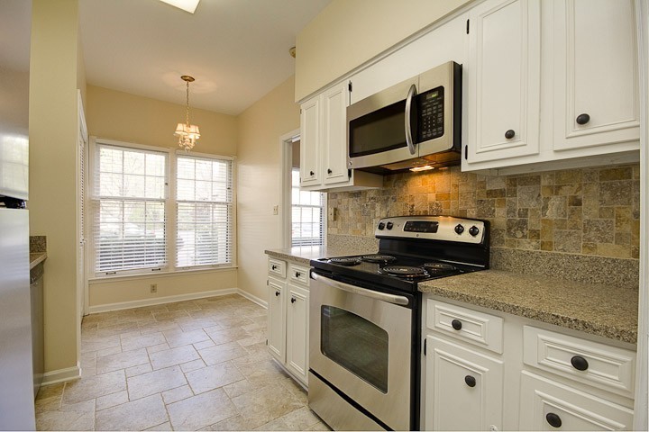 4505 Harding Pike, Unit 106 Nashville, TN 37205 - Photo 13 of 22 a kitchen with stainless steel appliances granite countertop a stove a microwave and a white cabinets