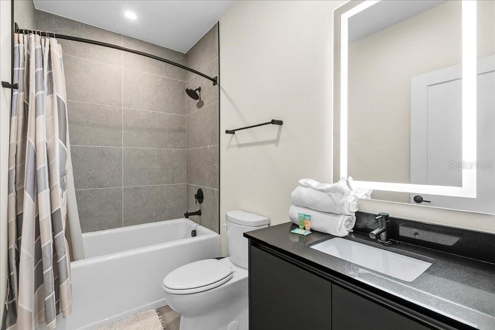 1385 Peaceful Way Clermont, FL 34714 - Photo 23 of 28 a bathroom with a granite countertop sink a toilet and shower