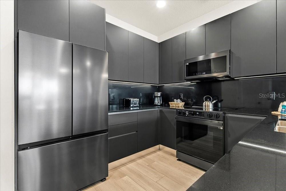 1385 Peaceful Way Clermont, FL 34714 - Photo 7 of 28 a kitchen with stainless steel appliances granite countertop a refrigerator a stove and a sink with wooden floor