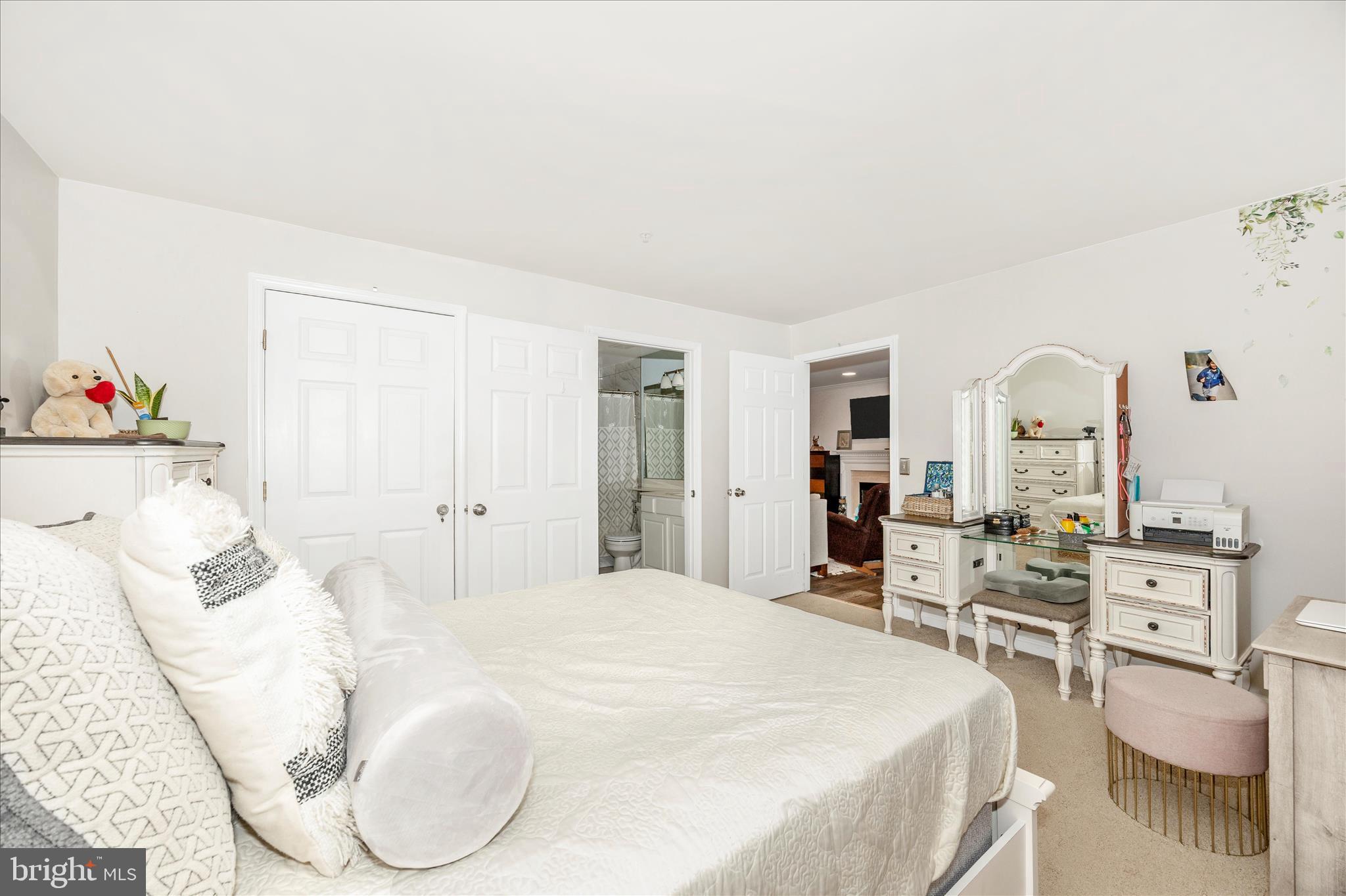 125 Timberbrook Lane, Unit 102 Gaithersburg, MD 20878 - Photo 19 of 38 a large bedroom with a bed and glass table with chair
