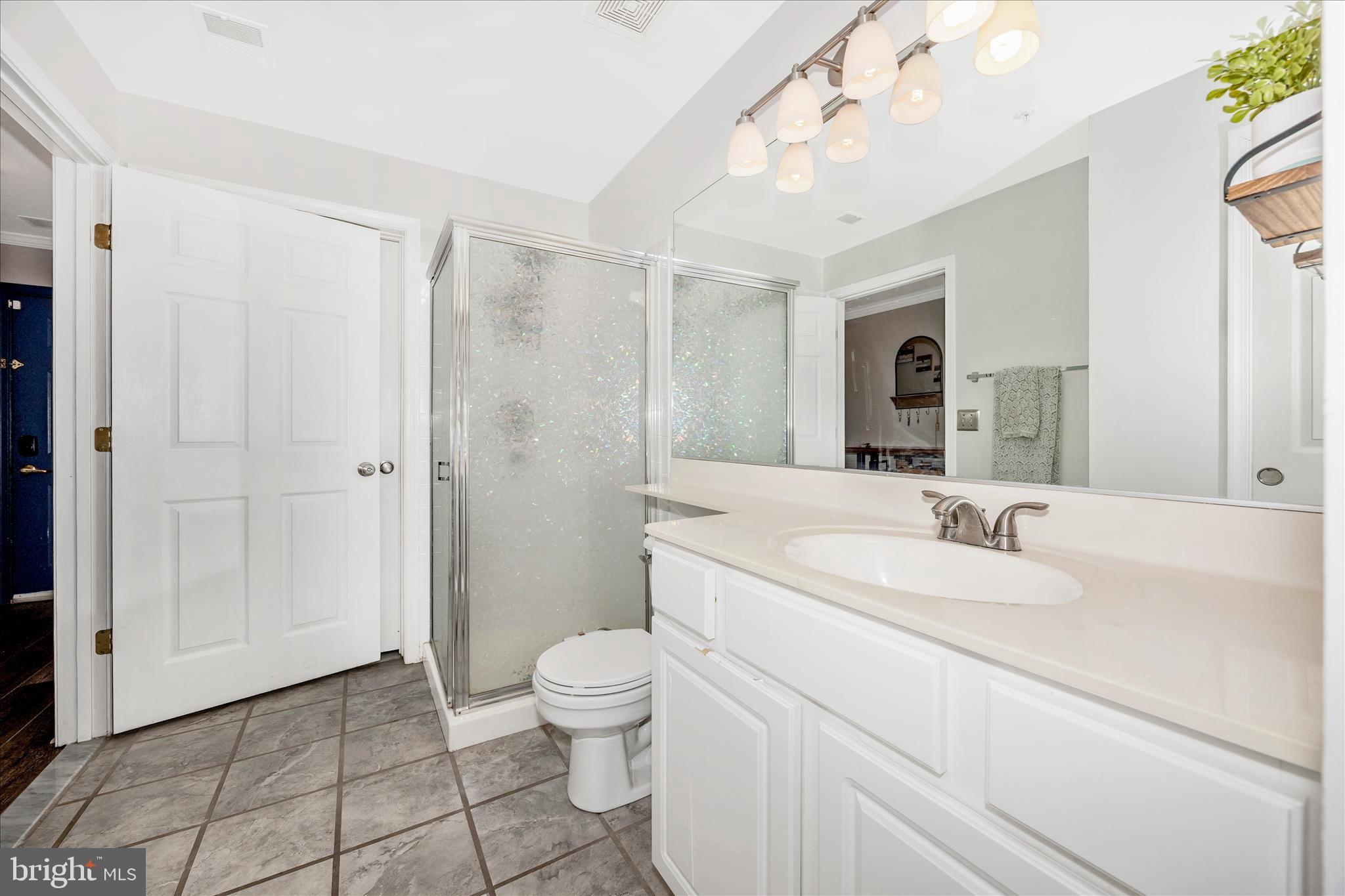 125 Timberbrook Lane, Unit 102 Gaithersburg, MD 20878 - Photo 23 of 38 a spacious bathroom with a granite countertop sink a toilet a mirror and shower