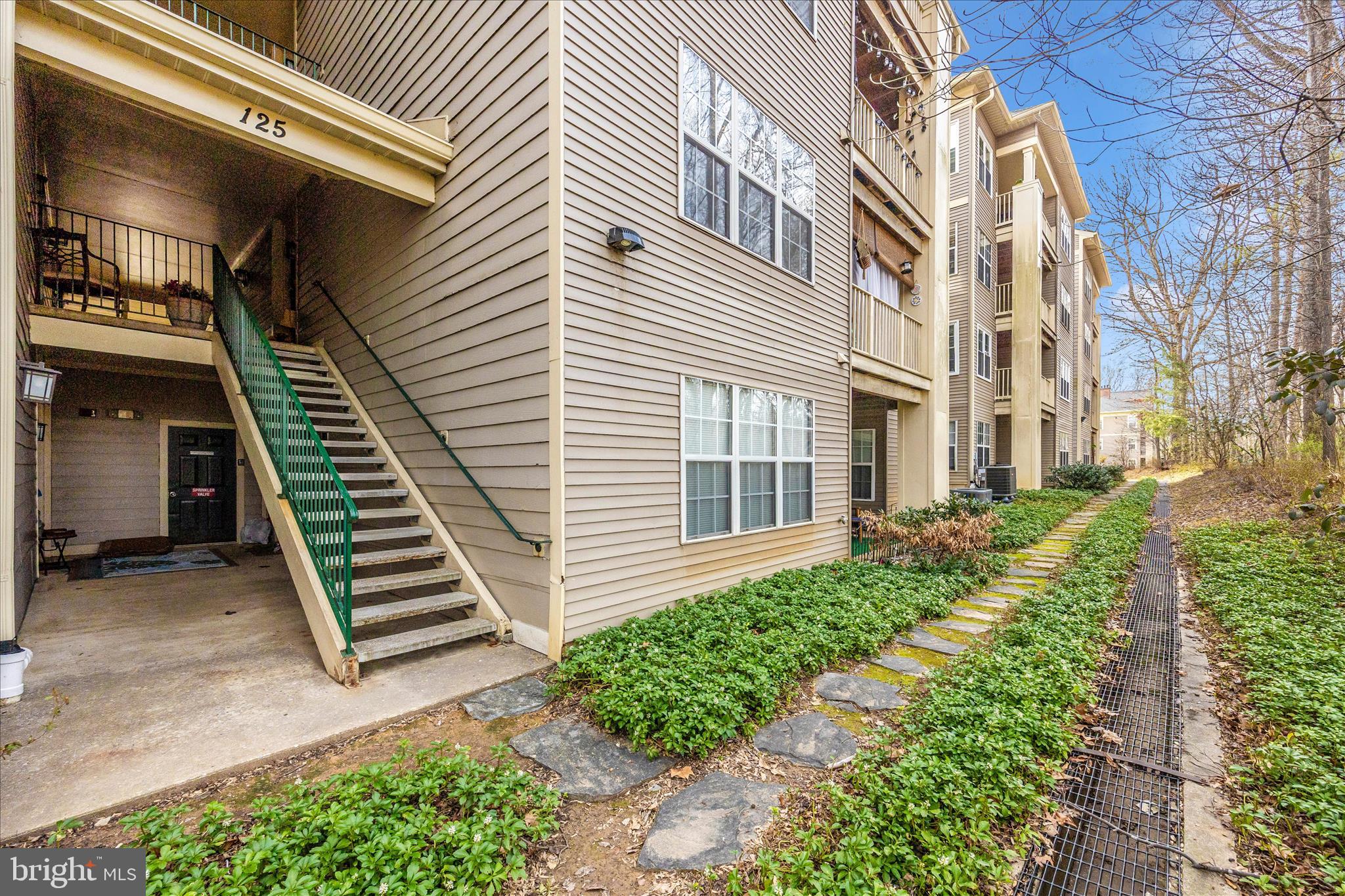 125 Timberbrook Lane, Unit 102 Gaithersburg, MD 20878 - Photo 29 of 38 a front view of a multi story residential apartment building with a yard