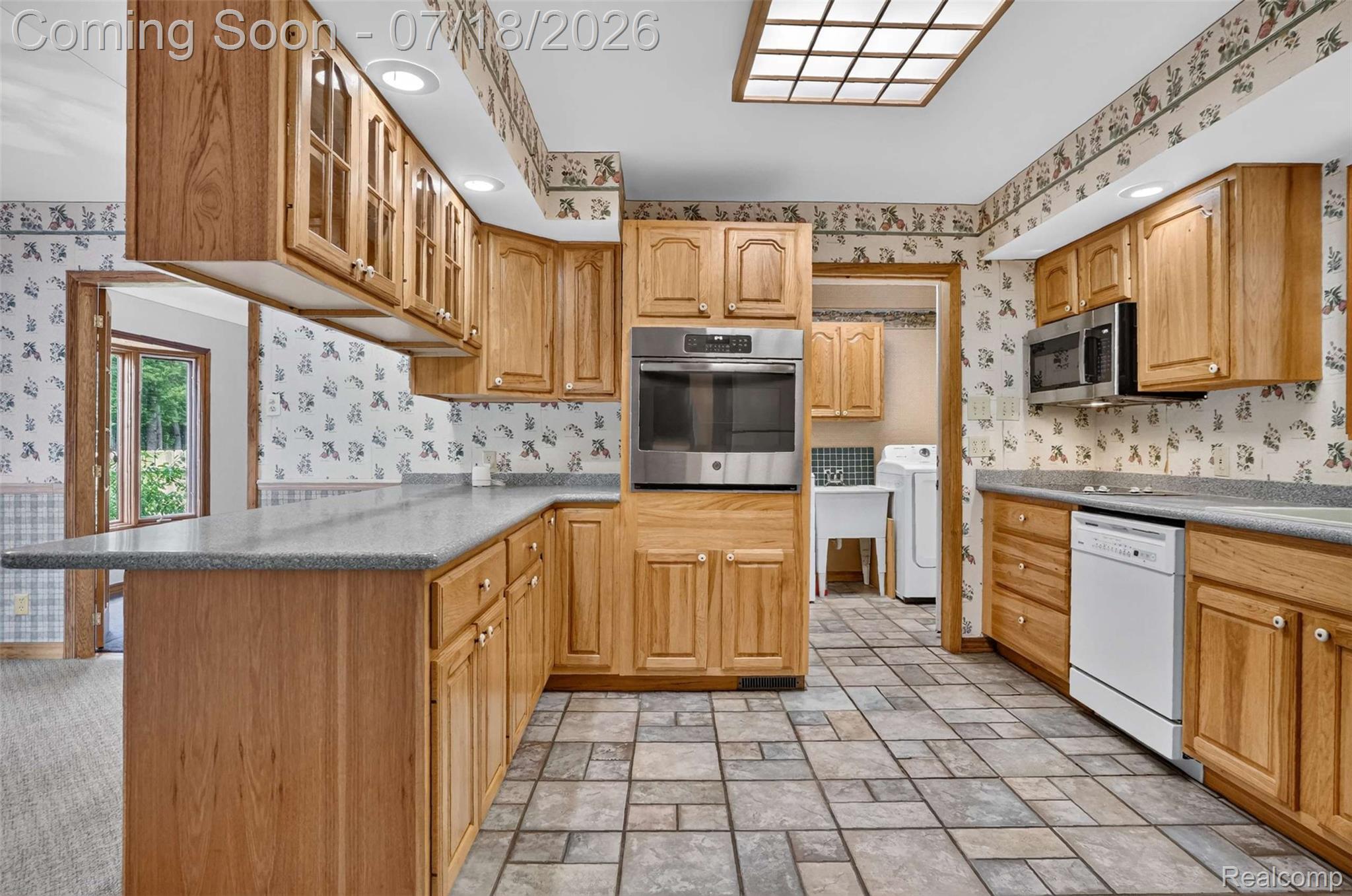 1437 East Cook Road Grand Blanc, MI 48439 - Photo 43 of 69 Kitchen featuring natural wood cabinetry, stone-finish countertops, stainless steel wall oven, stainless steel microwave, and integrated dishwasher