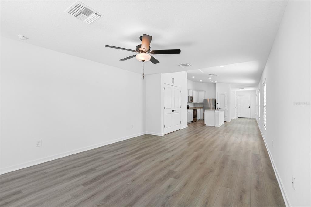 13053 Trapper John Road Weeki Wachee, FL 34614 - Photo 4 of 7 a view of empty room with wooden floor and ceiling fan