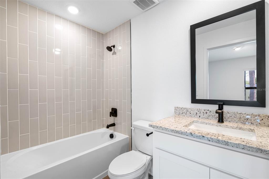 13053 Trapper John Road Weeki Wachee, FL 34614 - Photo 7 of 7 a bathroom with a granite countertop sink toilet and shower