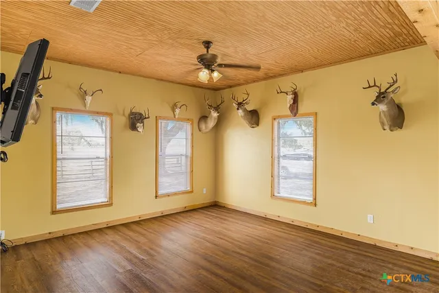 a view of a room with wooden floors and ceiling fan