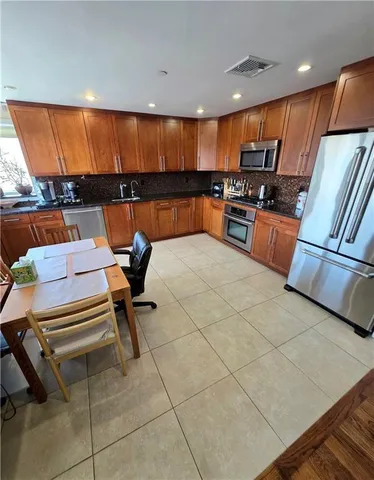 a kitchen with stainless steel appliances kitchen island granite countertop a refrigerator and stove