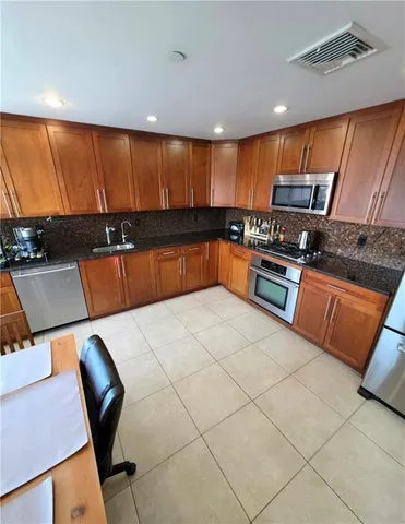 a kitchen with stainless steel appliances kitchen island granite countertop a sink and cabinets