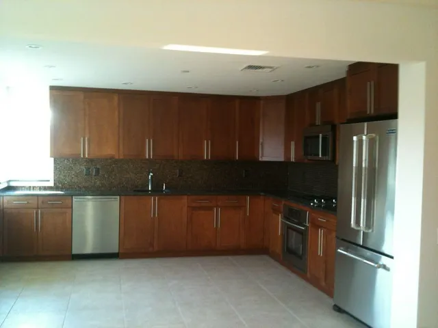 a kitchen with stainless steel appliances granite countertop a refrigerator and a sink