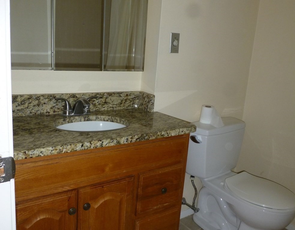 116 Russet Lane, Unit 116 Boxborough, MA 01719 - Photo 13 of 22 a bathroom with a granite countertop sink a toilet and a mirror