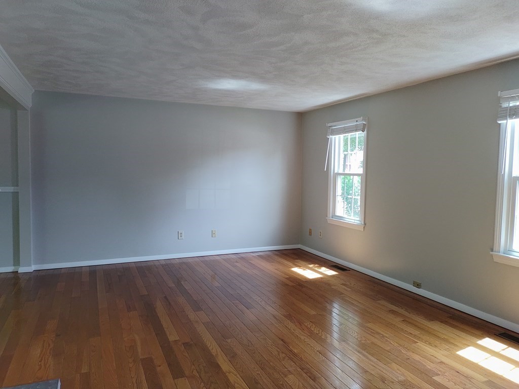 116 Russet Lane, Unit 116 Boxborough, MA 01719 - Photo 3 of 22 a view of an empty room with wooden floor and a window
