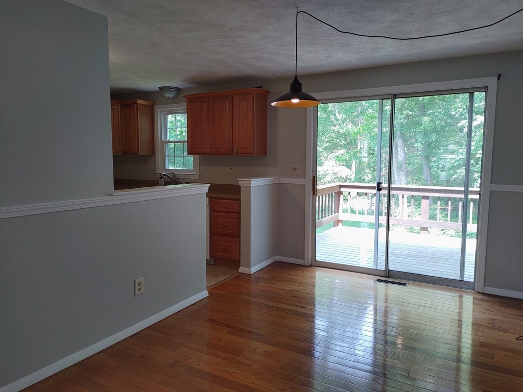 116 Russet Lane, Unit 116 Boxborough, MA 01719 - Photo 4 of 22 wooden floor in an empty room with a window