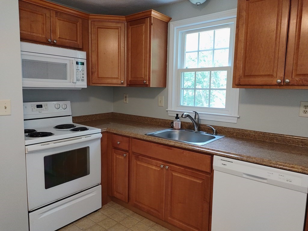 116 Russet Lane, Unit 116 Boxborough, MA 01719 - Photo 7 of 22 a kitchen with stainless steel appliances granite countertop white cabinets and a stove top oven