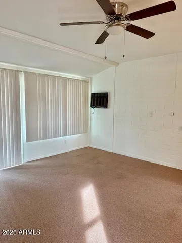 a view of a room with a ceiling fan and a window