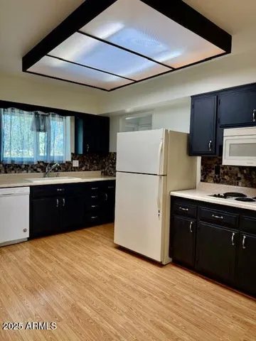 a kitchen with stainless steel appliances granite countertop a refrigerator a sink dishwasher a stove top oven a refrigerator and cabinets