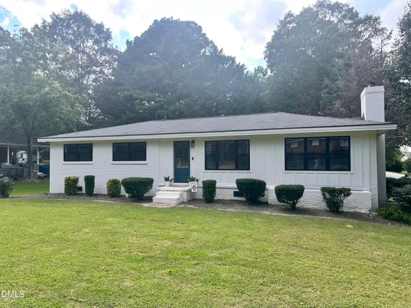 a front view of house with yard seating and green space