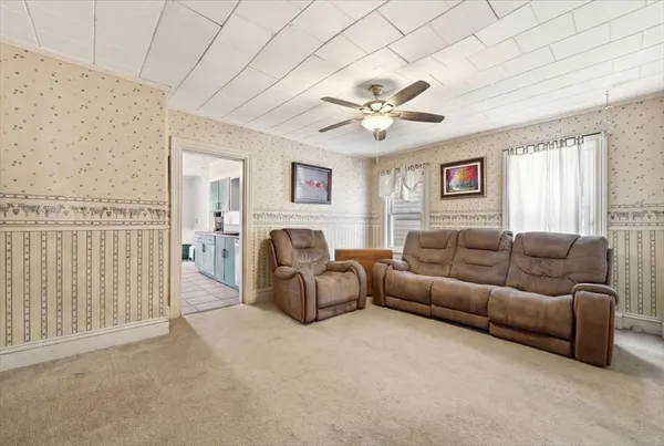 a living room with furniture a fireplace and a chandelier