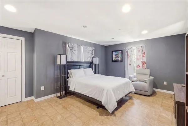 a bedroom with a large bed and a chandelier