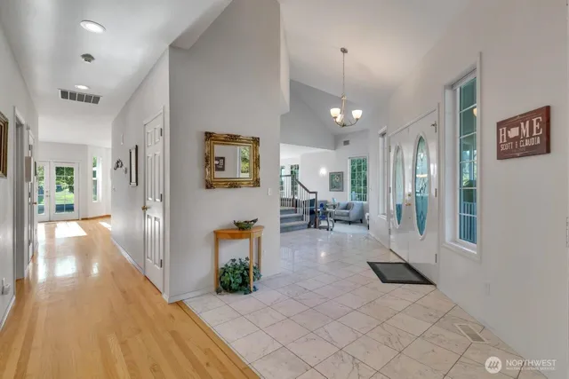 a view of a hallway with wooden floor and furniture