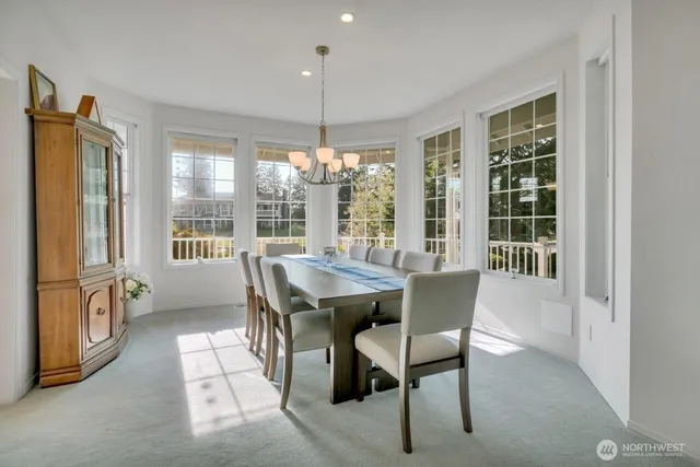 a dining room with furniture a chandelier and window