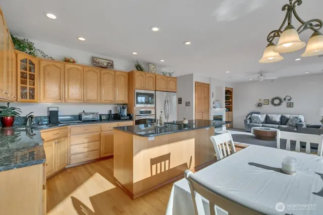 a large kitchen with kitchen island a large counter top appliances and cabinets