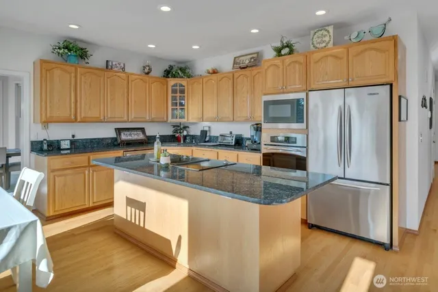 a kitchen with stainless steel appliances granite countertop a sink refrigerator and microwave