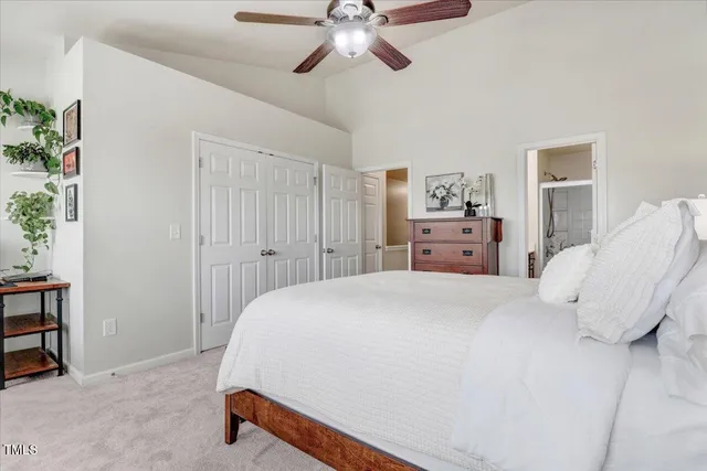 a spacious bedroom with a large bed a chandelier and a couch