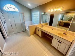 7786 Scarlet Court Naples, FL 34104 - Photo 8 of 14 a spacious bathroom with a double vanity sink and a mirror