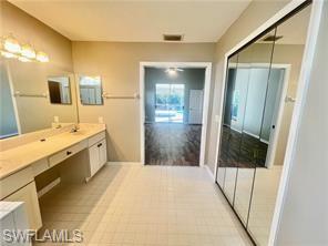 7786 Scarlet Court Naples, FL 34104 - Photo 9 of 14 a bathroom with a sink a mirror and a shower