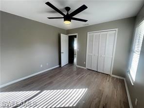 7786 Scarlet Court Naples, FL 34104 - Photo 10 of 14 an empty room with wooden floor and windows