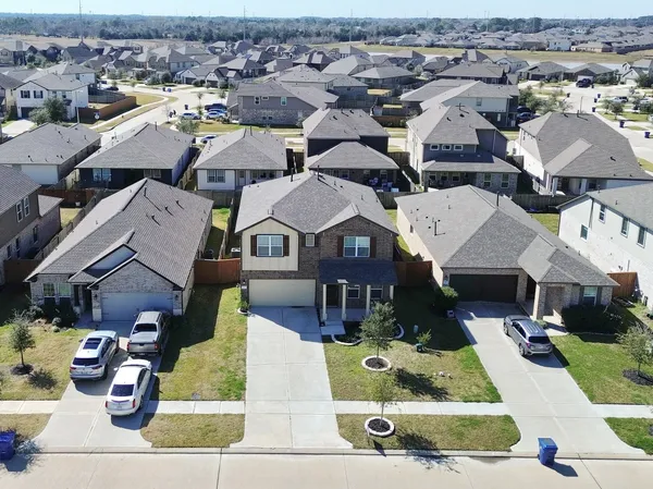 an aerial view of a residential houses with yard