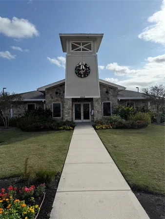 a front view of a house with a yard and potted plants