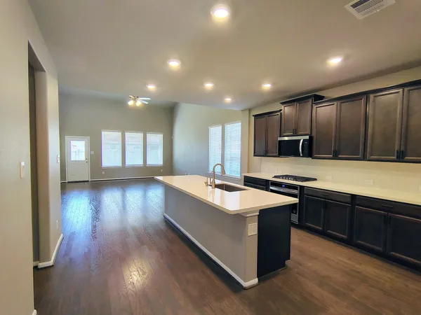 a large kitchen with lots of counter space sink and a refrigerator