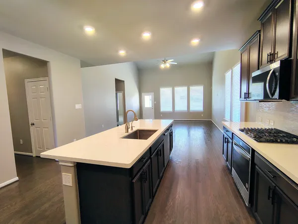 a kitchen with kitchen island a sink stove and wooden floor