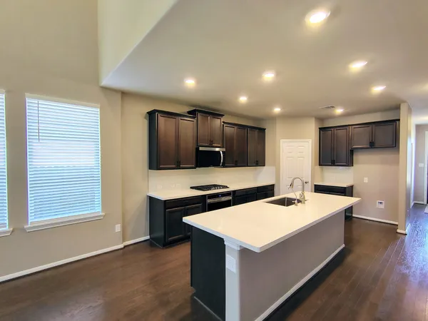 a kitchen that has a sink a stove top oven and refrigerator