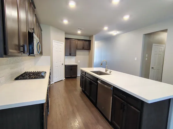 a large kitchen with stainless steel appliances a large counter top