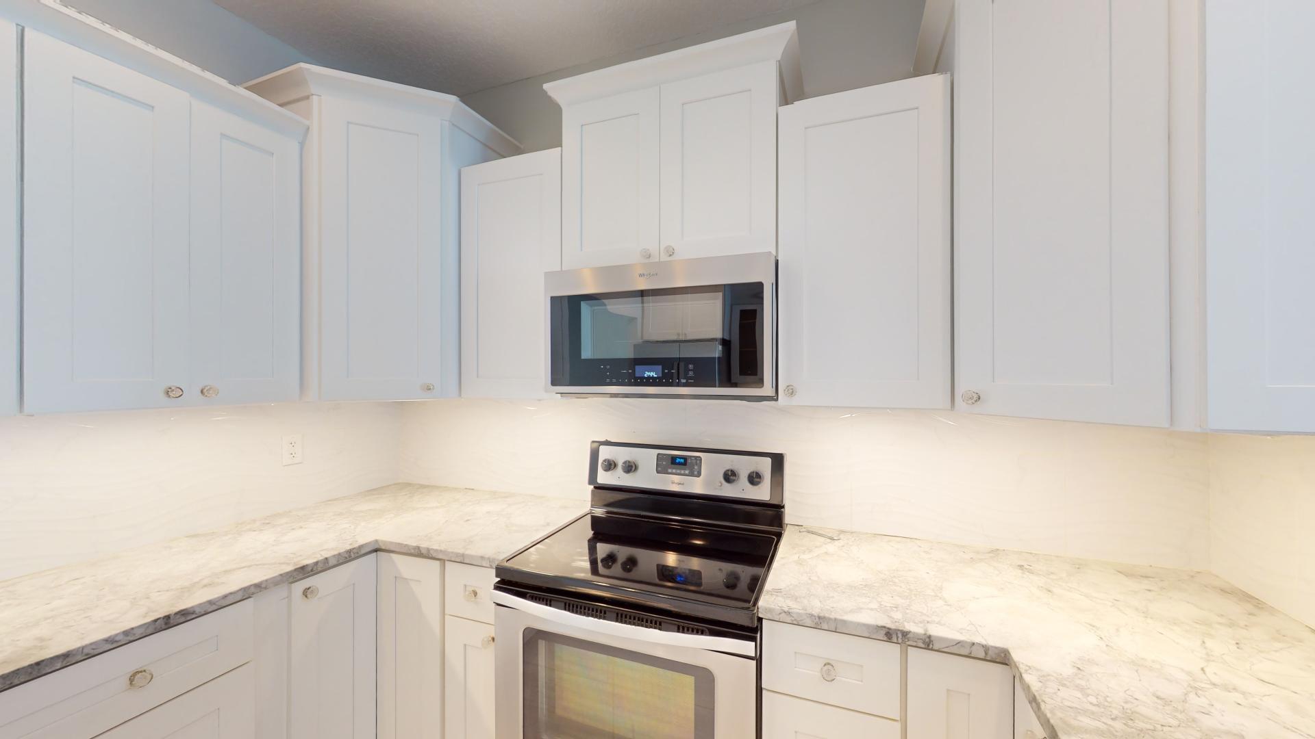 959 N Highway Indialantic, FL 32903 - Photo 12 of 70 a kitchen with granite countertop white cabinets and black appliances