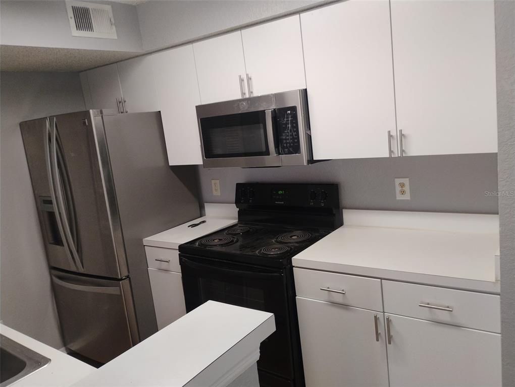 2202 Key W Court, Unit 633 Kissimmee, FL 34741 - Photo 6 of 33 a kitchen with a refrigerator sink and microwave