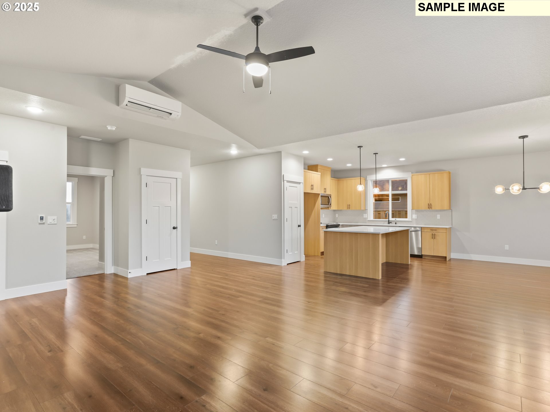 2240 East Otter Loop, Unit 52 La Center, WA 98629 - Photo 10 of 43 a view of a kitchen with a kitchen island wooden floor appliances and a ceiling fan