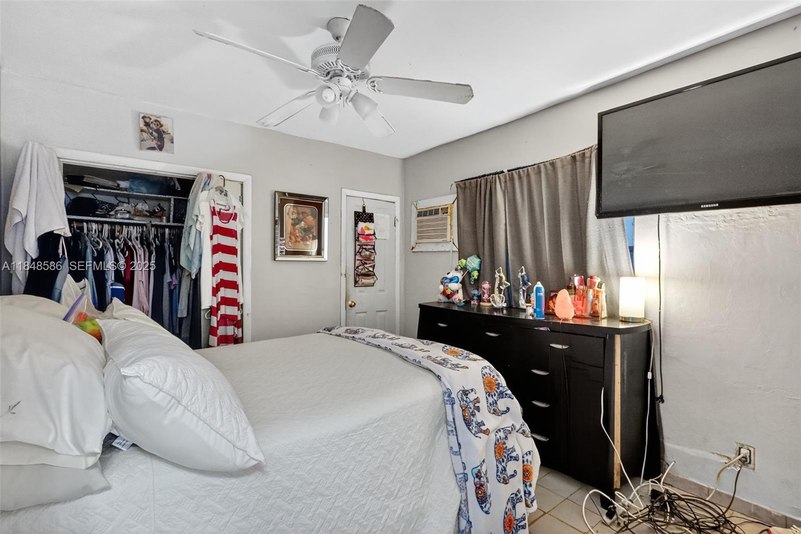 3581 West 2nd Avenue Hialeah, FL 33012 - Photo 15 of 32 a bedroom with a bed and a chandelier