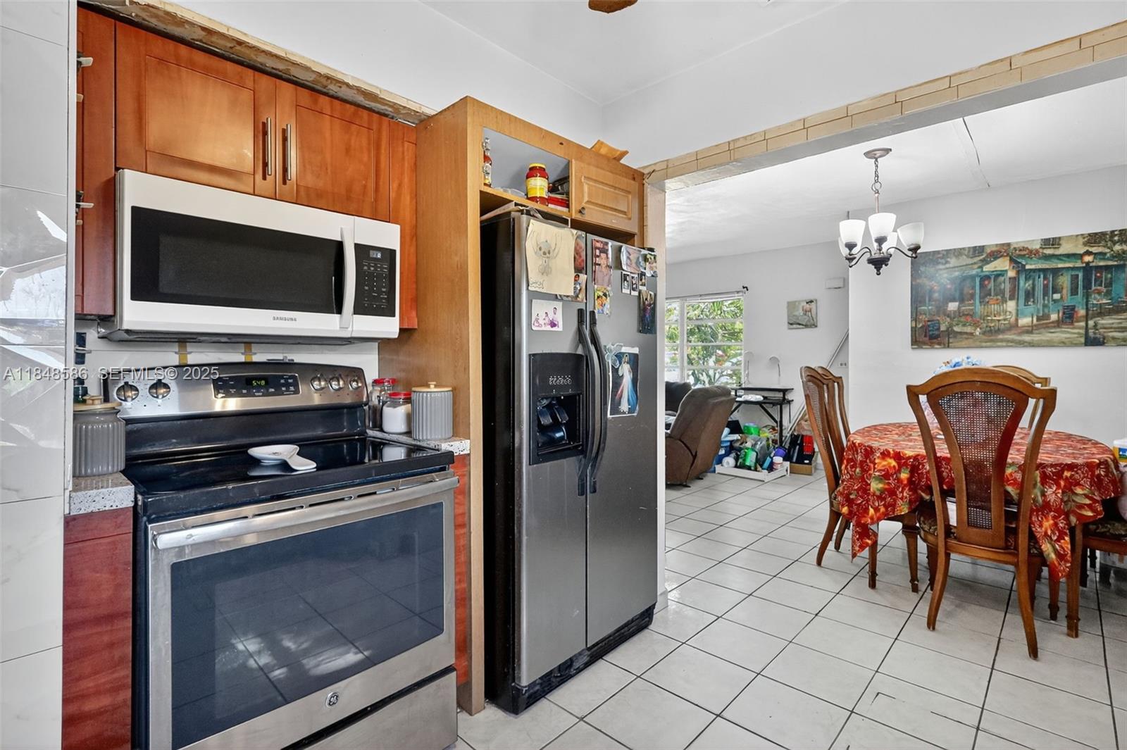 3581 West 2nd Avenue Hialeah, FL 33012 - Photo 6 of 32 a kitchen with stainless steel appliances a stove microwave and a dining table