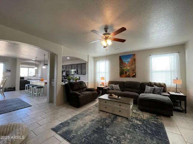 a living room with furniture ceiling fan and a window
