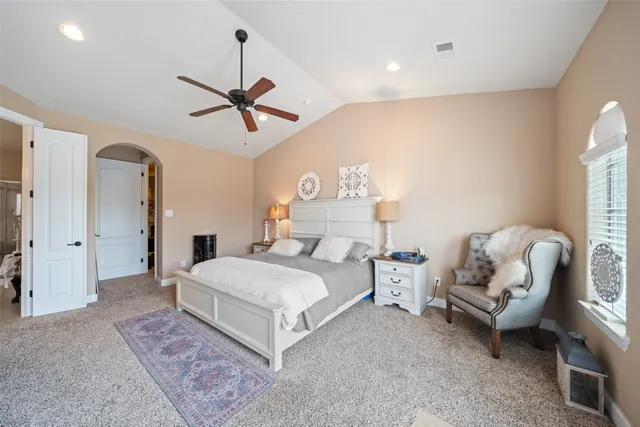 a spacious bedroom with two beds and chandelier