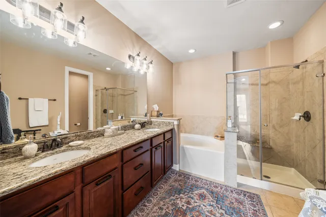 a bathroom with a sink double vanity granite tub and shower