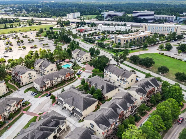 front view of a brick house with a yard and large trees