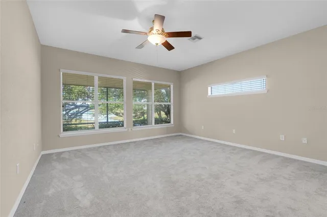 a view of an empty room with a ceiling fan