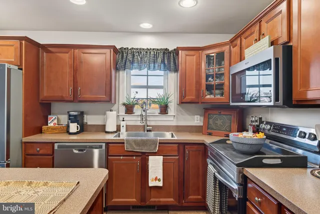 a kitchen with stainless steel appliances granite countertop a sink stove and cabinets