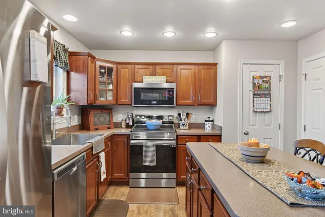 a kitchen with stainless steel appliances granite countertop a refrigerator a stove top oven a sink and dishwasher