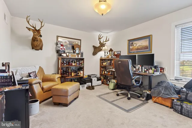 a view of a workspace with furniture and a window